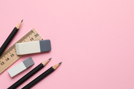 Erasers, ruler and pencils on pink background, flat lay. Space for textの写真素材