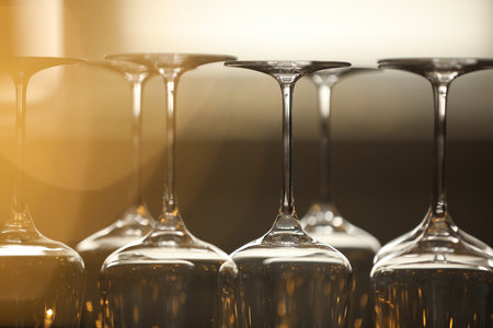 Upturned empty clean glasses on blurred background, closeup. Bokeh effectの写真素材