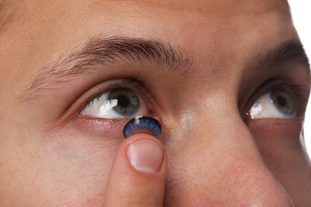 Man putting color contact lens in his eye, closeupの写真素材