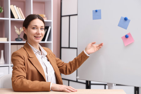 Smiling online speaker performing webinar near flip chart indoorsの写真素材