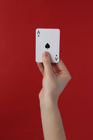 Woman with playing card against red background, closeup