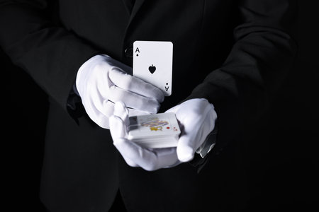 Illusionist with playing cards on black background, closeupの写真素材