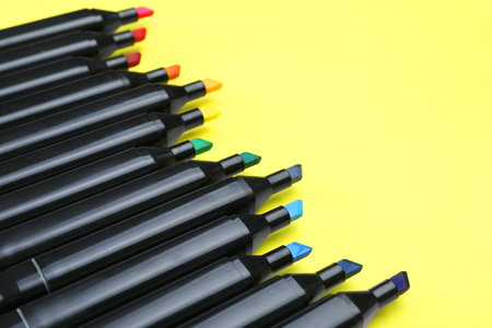 Colorful markers on yellow background, closeup. Space for textの写真素材