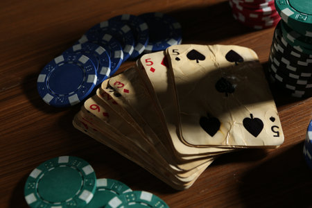 Old vintage playing cards and poker chips on wooden table, closeupの写真素材