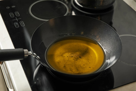 Cooking oil in frying pan on stove in kitchenの写真素材