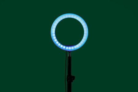 Ring lamp on stand against green background