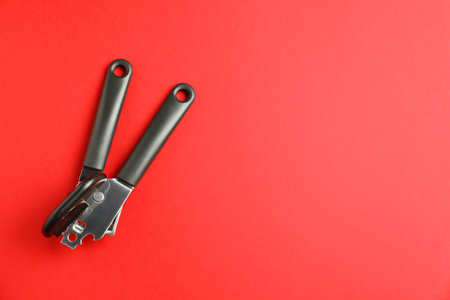 One can opener on red background, top view. Space for textの写真素材