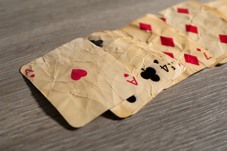 Many old vintage playing cards on wooden table, closeup
