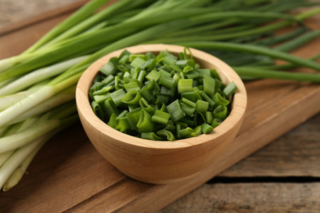 Fresh green onions on wooden table, closeupの写真素材