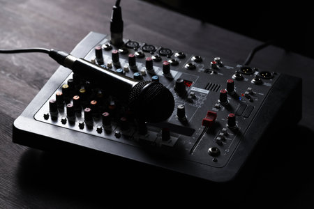 Professional mixing console with microphone on dark wooden table, closeupの写真素材