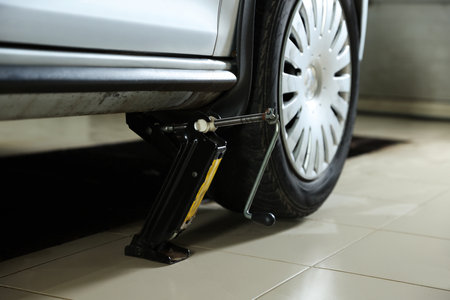 Car lifted by scissor jack at service stationの写真素材