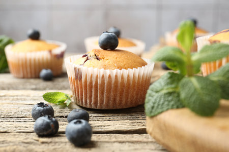 Delicious muffins with blueberries and mint on wooden table, closeupの写真素材