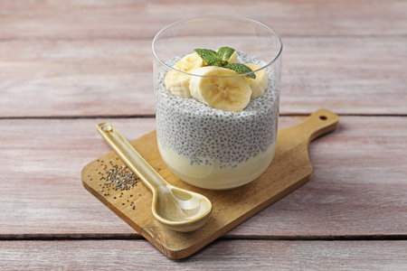 Delicious chia pudding with banana and mint in glass served on wooden table, closeupの写真素材