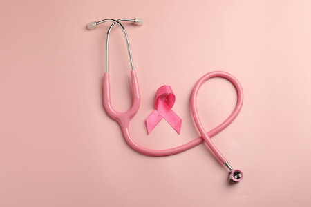 Breast cancer awareness. Pink ribbon and stethoscope on color background, flat layの写真素材