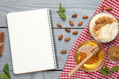 Blank recipe book, dessert and ingredients on grey wooden table, flat layの写真素材