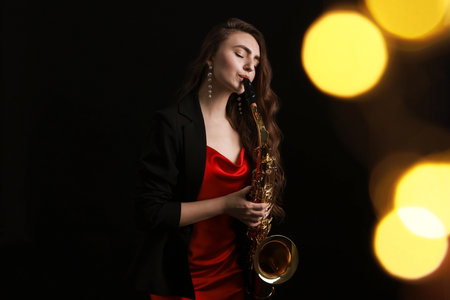 Professional musician playing saxophone on black background with blurred lights. Bokeh effectの写真素材