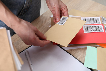 Woman with many different envelopes at table in post office, closeupの写真素材