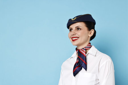 Smiling flight attendant on light blue background.の写真素材