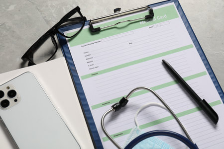 Composition with medical card form and pen on grey background, closeupの写真素材