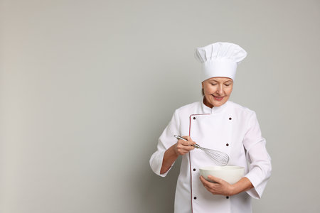 Professional pastry chef cooking on light grey background. Space for textの写真素材