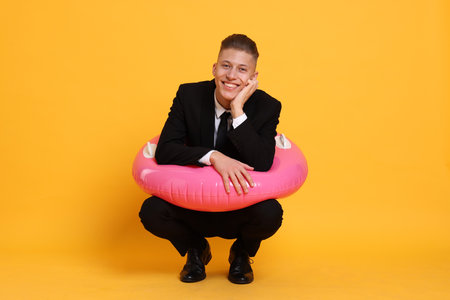 Man with inflatable ring on orange backgroundの写真素材