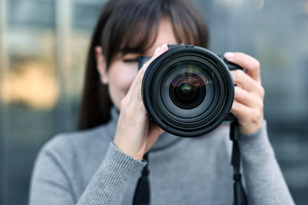 Professional photographer taking picture with camera outdoors, selective focus