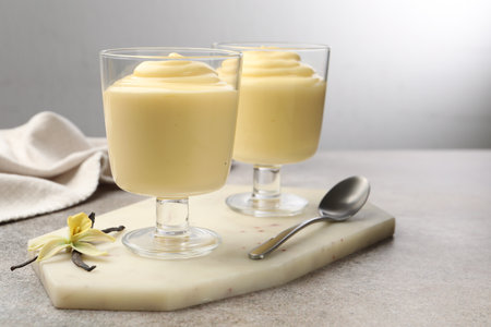 Tasty vanilla pudding, pods and flower on grey tableの写真素材