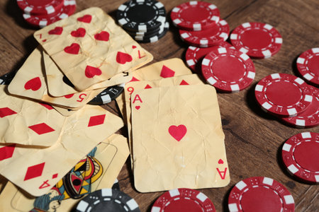Old vintage playing cards and poker chips on wooden table, closeupの写真素材