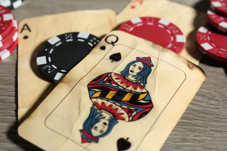 Old vintage playing cards and poker chips on wooden table, closeupの写真素材