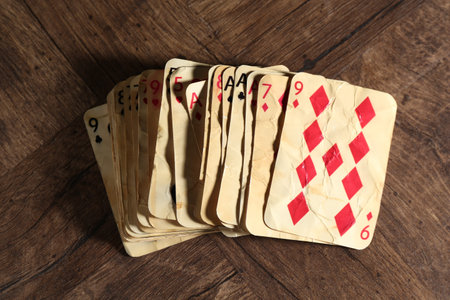 Old vintage playing cards on wooden table, flat lay