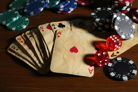 Old vintage playing cards, poker chips and dices on wooden table, closeupの写真素材