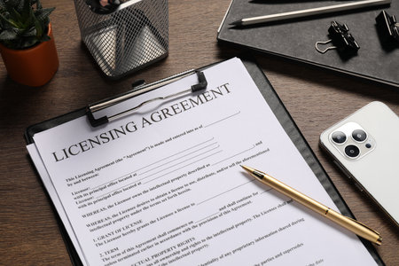 Licensing agreement document, stationery and smartphone on wooden table, closeupの写真素材