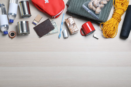 Earthquake supply kit on wooden table, flat lay. Space for text