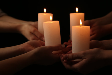 Women with burning candles on dark background, closeupの写真素材
