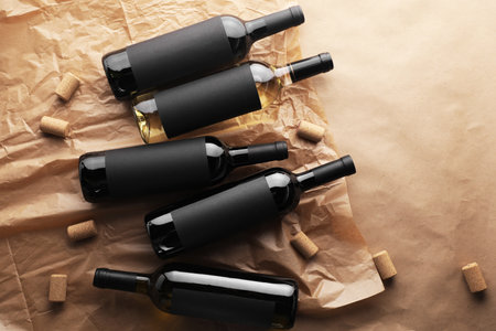 Bottles of wine and corks on parchment paper, flat lay. Space for textの写真素材