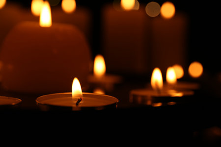 Many burning candles on dark surface, closeupの写真素材
