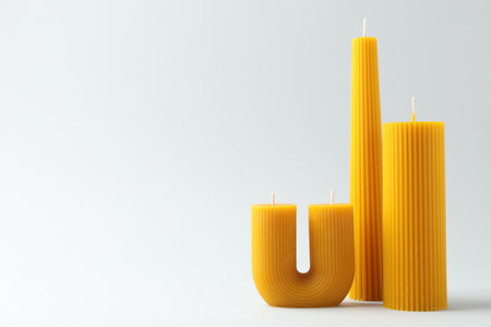 Beautiful beeswax candles on white background, space for textの写真素材
