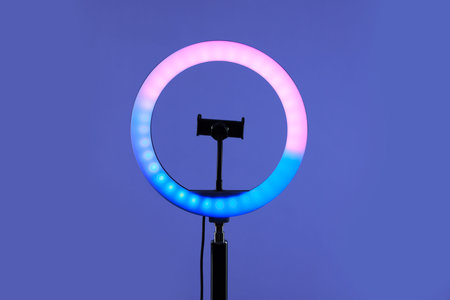 Ring lamp with holder for smartphone against purple background