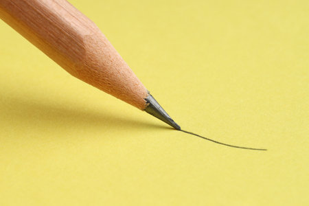 Drawing stroke with graphite pencil on yellow background, closeupの写真素材
