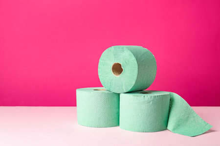 Green toilet paper rolls on pink background. Space for textの写真素材