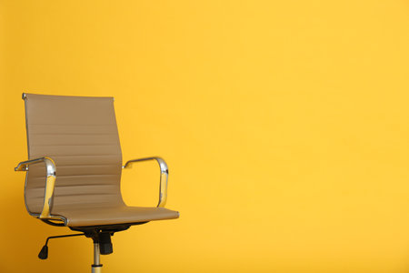 Modern office chair on yellow background. Space for textの写真素材