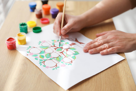 Woman drawing family tree at wooden table, closeupの写真素材