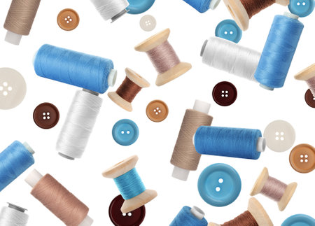 Colorful sewing threads and buttons flying on white backgroundの写真素材