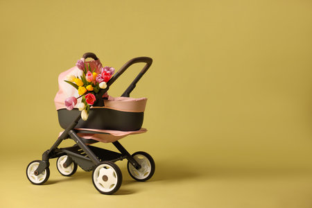 Stylish doll stroller and tulips on background, space for text. Kid's toyの写真素材