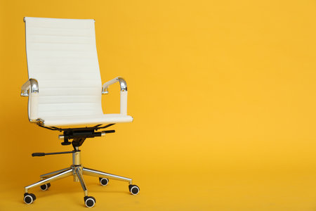 Modern office chair on yellow background. Space for textの写真素材