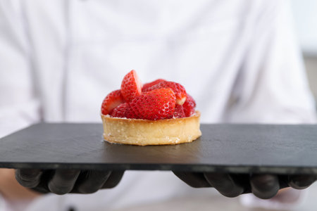 Confectioner with tasty tart in kitchen, closeupの写真素材