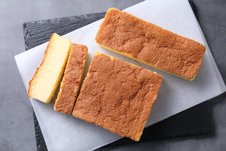 Tasty Japanese Castella sponge cake on grey table, top view