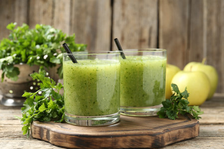Healthy parsley smoothie in glasses and leaves on wooden table, closeupの写真素材