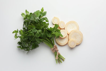 Pieces of parsley roots and leaves on white background, flat layの写真素材