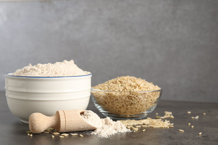 Brown rice and flour on grey table. Space for textの写真素材